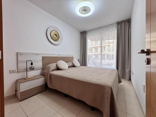 a bedroom with a bed with a clock on the wall at Poseidon 6 - cozy apartment with swimming pool in Puerto de Santiago