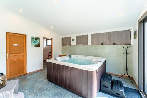 een grote badkamer met een hot tub in de kamer bij Le Gite au coin du feu in Cabannes