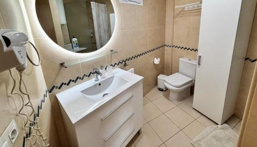 a bathroom with a sink and a mirror and a toilet at Poseidon 6 - cozy apartment with swimming pool in Puerto de Santiago