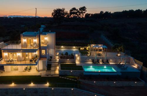 a villa with a swimming pool at night at Villa Oasis in Galatás