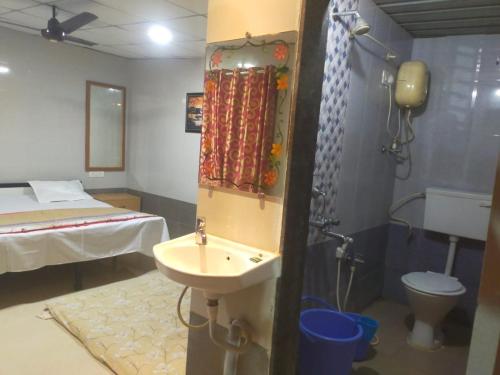 a room with a bathroom with a sink and a bed at Sai Samata Lodging Boarding in Junnar
