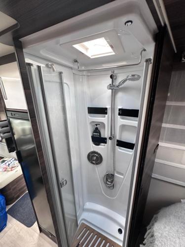 a small bathroom with a shower in a trailer at Arctic Shaman Adventures -Jurtta in Köngäs