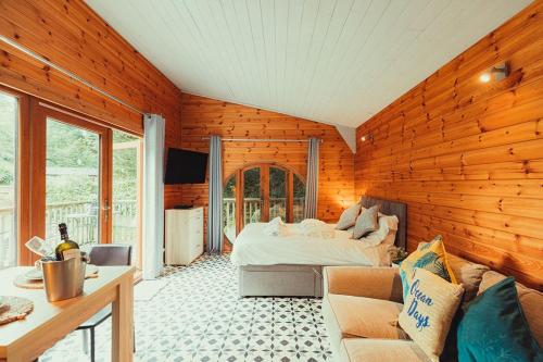 a living room with a bed and a couch at Robin Woodside Lodge in Caerwys