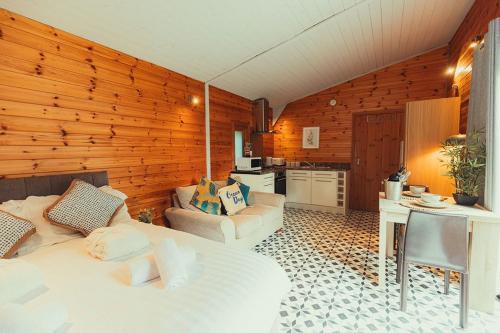 a living room with a bed and a kitchen at Robin Woodside Lodge in Caerwys