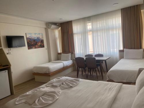 ein Hotelzimmer mit zwei Betten und einem Tisch und Stühlen in der Unterkunft Alice İn Taksim Apart in Istanbul
