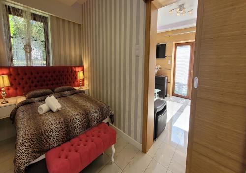 a bedroom with a large bed with a red headboard at Apartament 46m2 z tarasem i wanną Asenata Ustroń in Ustroń