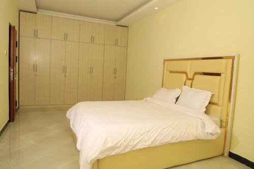 une chambre avec un grand lit avec des draps blancs dans l'établissement Primenest - My Dream 3 bed room apartment near African Union, à Addis-Abeba