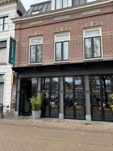 a brick building with large windows on a street at Tres Boutique Hotel in Gorinchem