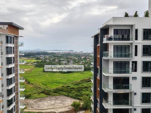 an aerial view of two buildings and a green field at K Avenue Lucky Stay Suite in Penampang