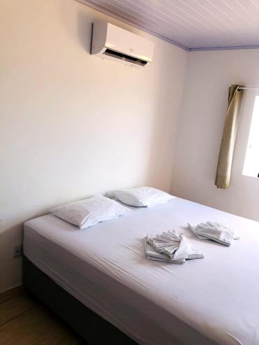 een slaapkamer met een wit bed met twee handdoeken erop bij Hotel Imperial in Santa Cruz