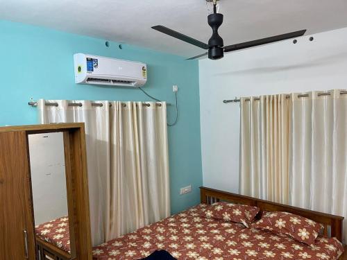 a bedroom with a bed and a ceiling fan at 3BHK AC Villa with Attached Baths in Trivandrum
