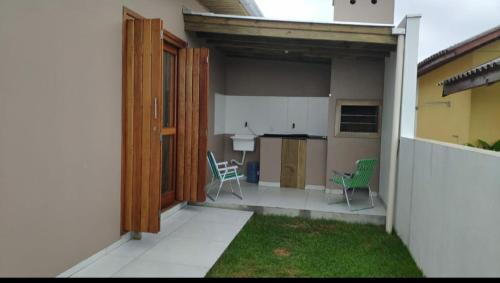 a patio with chairs and a kitchen in a house at Casa Beira-mar da Sumaré in Balneário Gaivotas
