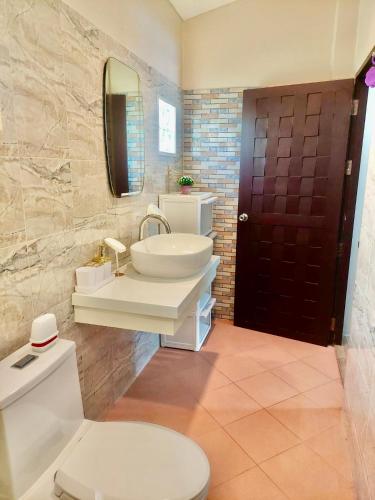 a bathroom with a sink and a toilet and a mirror at Leelawadee House - 3 bedroom private villa with pool in Nathon Bay