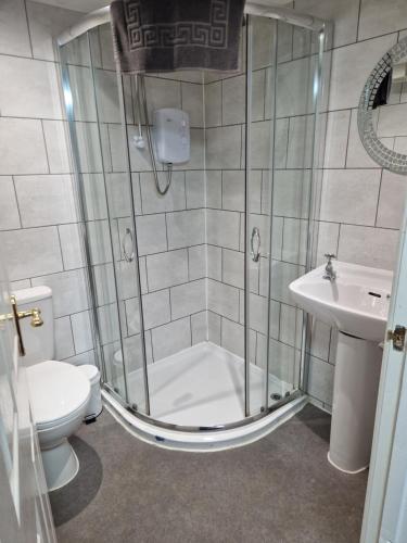 a bathroom with a shower and a toilet and a sink at The Swan Hotel in Lydney