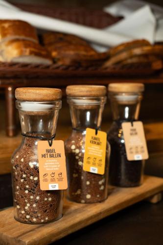 a shelf with four jars of bread and other items at Landgoed Duin & Kruidberg in Santpoort-Noord
