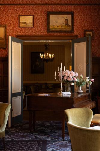 a dining room with a table with flowers and candles at Landgoed Duin & Kruidberg in Santpoort-Noord