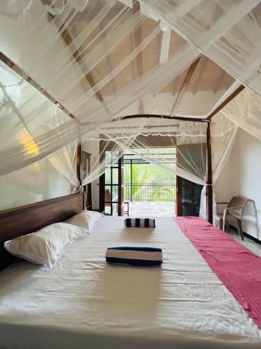 a bedroom with a large white bed in a room at Shells Villa Hikkaduwa in Hikkaduwa