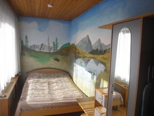 a bedroom with a bed with a mountain mural on the wall at Ferienwohnungen Strasser in Stockenboi