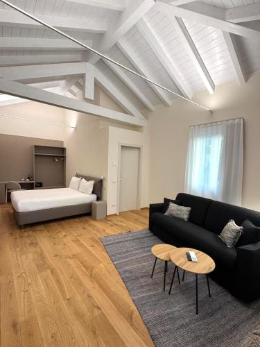 a living room with a bed and a couch and a table at Cà del Borgo in Vizzola Ticino