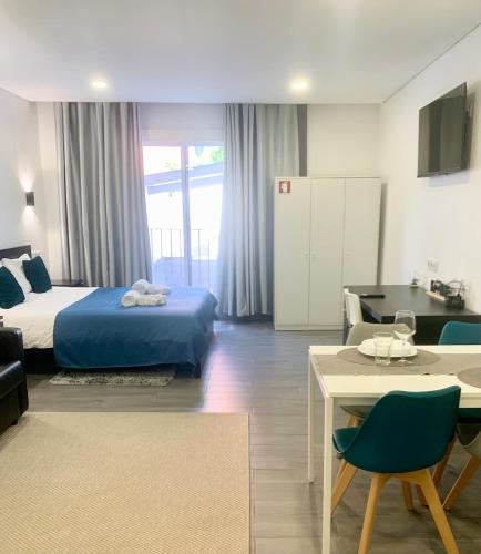 a hotel room with a bed and a table and chairs at Almada Downtown 103 in Porto