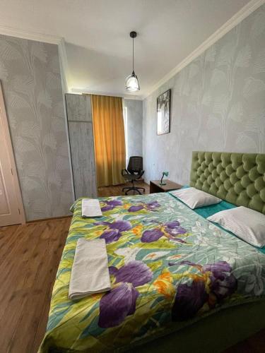 a bedroom with a large bed with a colorful blanket at Happy Rustavi guest house in Rustavi