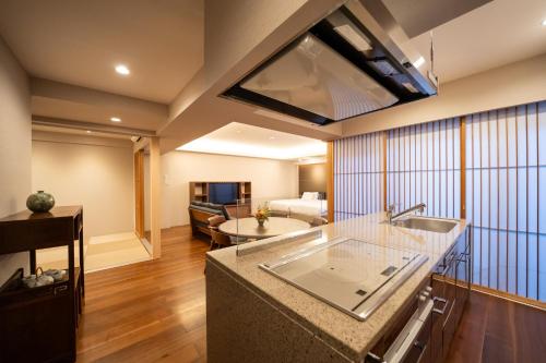 a kitchen with a sink and a living room at 御屋 清水紫翠庵 in Kyoto