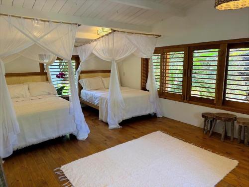 een slaapkamer met twee bedden met witte gordijnen bij Villa Verde in Trancoso