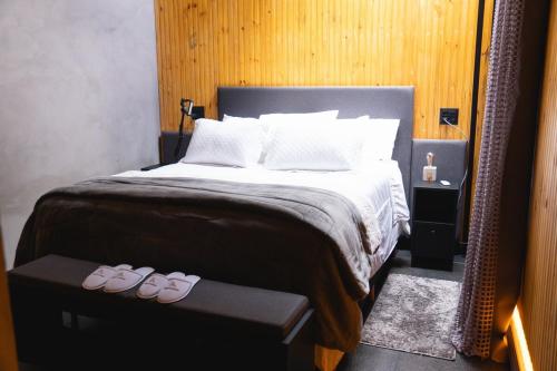 a bedroom with a bed with two pairs of slippers at Luxury Cabin at 1,600m altitude in São Bento do Sapucaí