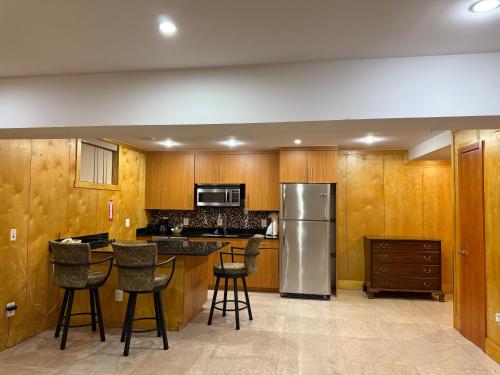 a kitchen with wooden cabinets and a stainless steel refrigerator at The Eldon Luxury Suites in Washington, D.C.