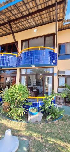 una grande casa con un ponte blu e giallo di Fantástica Casa 02 Quartos nas belas praias do Flamengo a Salvador