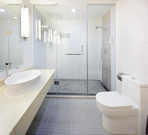 ein Bad mit einem WC, einem Waschbecken und einer Dusche in der Unterkunft Guang Dong Hotel in Guangzhou