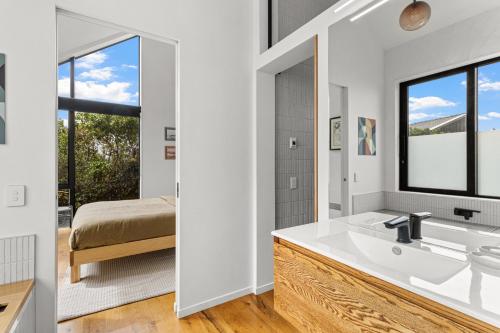 a bathroom with a tub and a sink and a bed at Seafront, Sauna, Architecture The Surf Nest Full House 