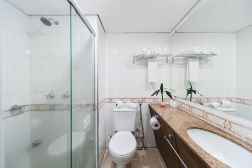 a bathroom with a toilet and a sink and a shower at Hotel Nacional Inn Curitiba Estação Shopping in Curitiba
