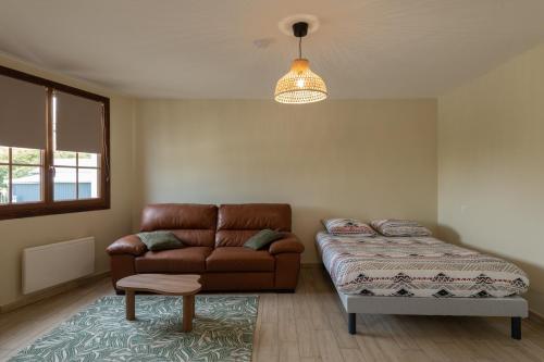 a living room with a couch and a bed at Le Reflet de Valéry - Proche Plage in Le Bois de Cise