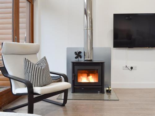 a living room with a chair and a fireplace at Waterside Lodge Thirteen - Uk11853 in Southowram