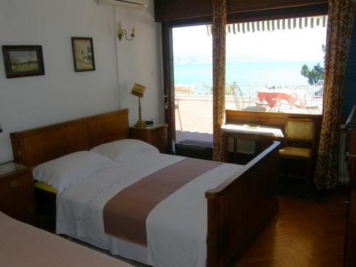 a bedroom with a bed with a view of the ocean at Apartments Darinka in Opatija