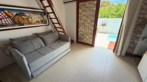 a living room with a couch and a ladder at Bangalô com tudo privativo em Tamandaré/PE in Tamandaré