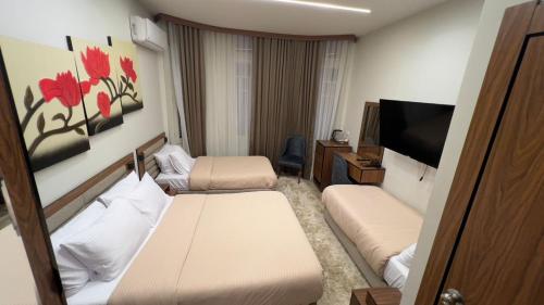 カイロにあるCairo Excellent Location hotelのベッド2台と薄型テレビ付きのホテルの部屋