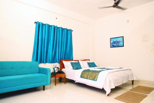 a bedroom with a bed and a blue couch at Solis Stay in Solapur