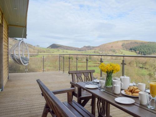 a wooden deck with a table with food on it at Red Kite Lodge - Uk32610 in Old Radnor