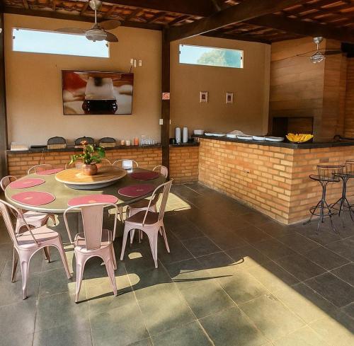 ein Zimmer mit Tisch und Stühlen und eine Küche in der Unterkunft Estância Pontello - próximo ao aeroporto de Confins in Confins