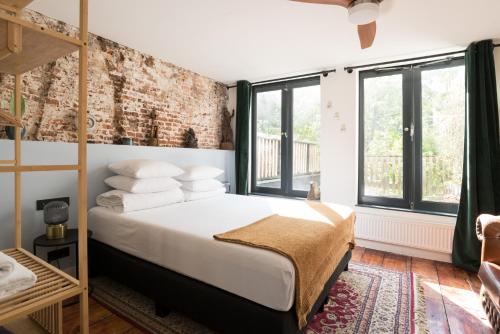a bedroom with a bed and a brick wall at Herenstraat Residence in Amsterdam