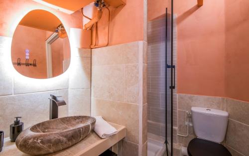 a bathroom with a sink and a toilet and a mirror at le cocon du beffroi centre ville in Millau