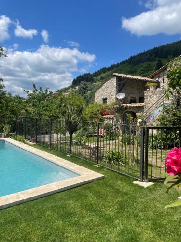 a fence with a pool in front of a house at Loft avec terrasse panoramique in Chirols