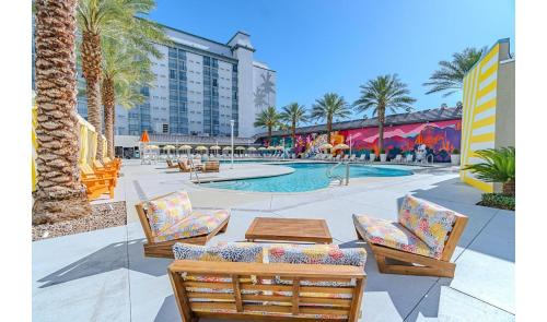 a pool with chairs and a table and a building at OYO Hotel and Casino Las Vegas in Las Vegas