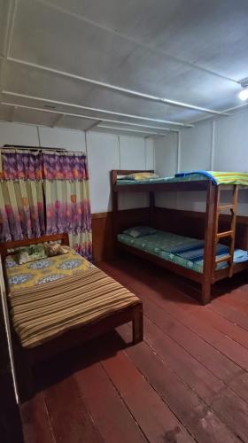 a room with two bunk beds and a wooden floor at Rima Hostel Ruteng in Ruteng
