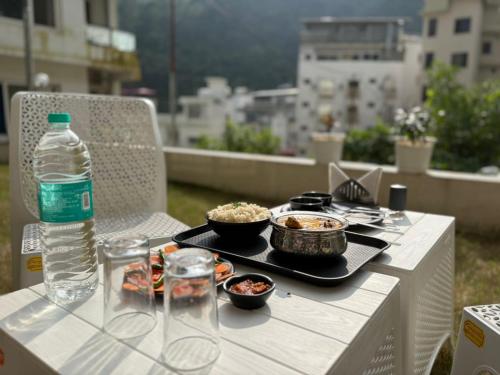una mesa de picnic con comida y una botella de agua en Hotel Abline the Oaks, en Rishīkesh