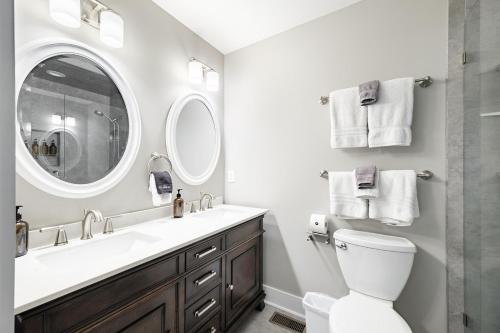 a bathroom with a sink and a toilet and a mirror at The Cove Retreat- Hot Tub/Screened Porch/Game Room in Lake Lure