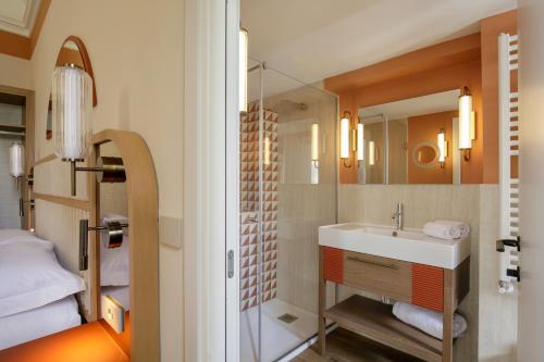 a bathroom with a sink and a mirror at Rosetta Hotel Perugia Tapestry Collection By Hilton in Perugia