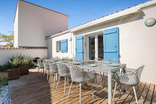 Un patio con una mesa y sillas en una terraza. en Le Temps de Vivre - Plage - Centre, en La Faute-sur-Mer